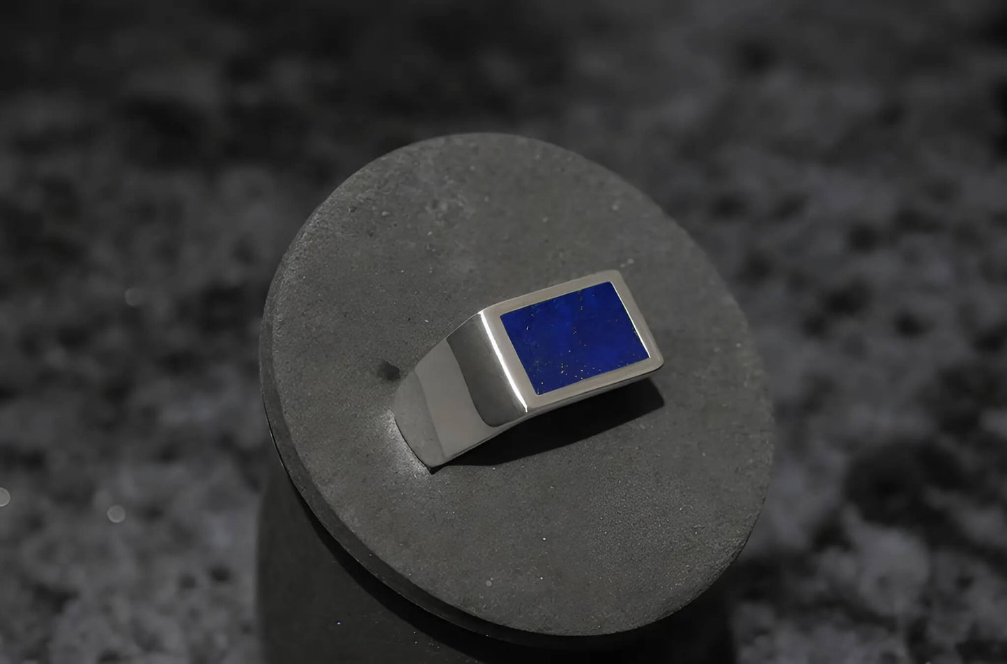 Close-up van de zilveren Lapis Lazuli ring met krasbewerking, die het vakmanschap en de textuur benadrukt.