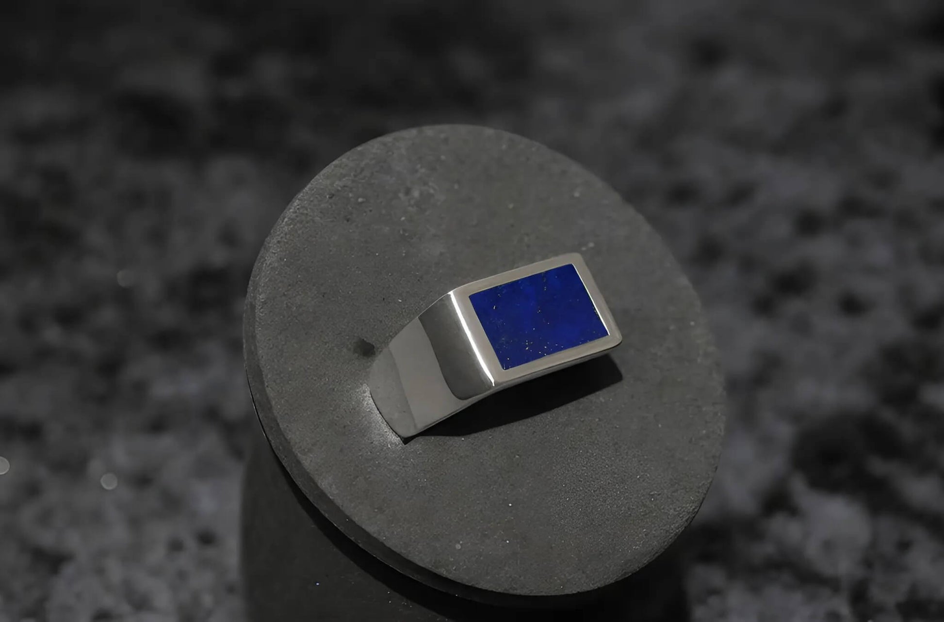 Close-up van de zilveren Lapis Lazuli ring met krasbewerking, die het vakmanschap en de textuur benadrukt.