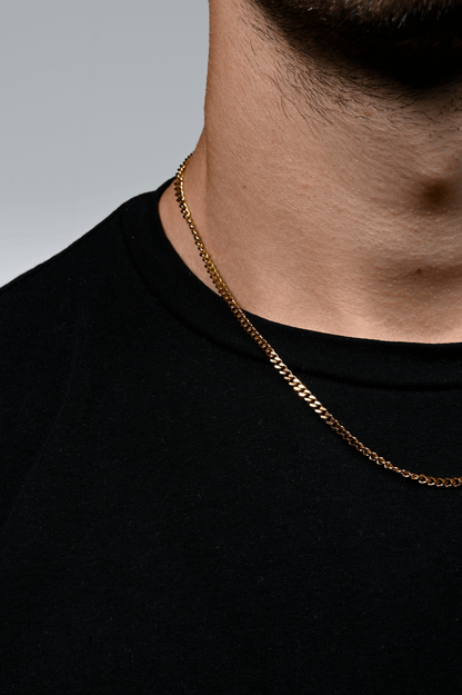 Gold-plated curb ketting gedragen door een model, met glanzende schakels