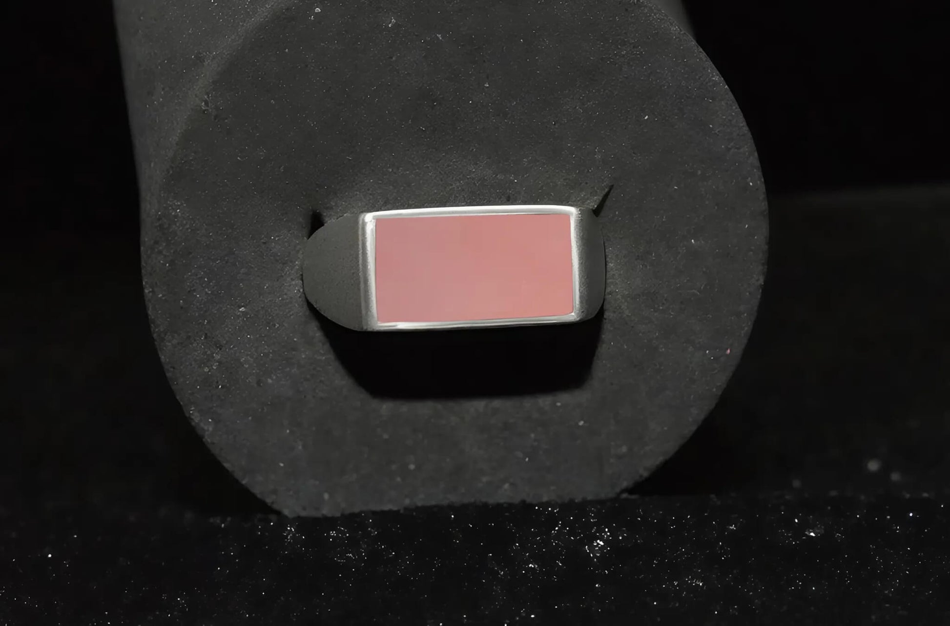 Een zegel ring met een roze steen close up.