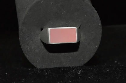 Een zegel ring met een roze steen close up.